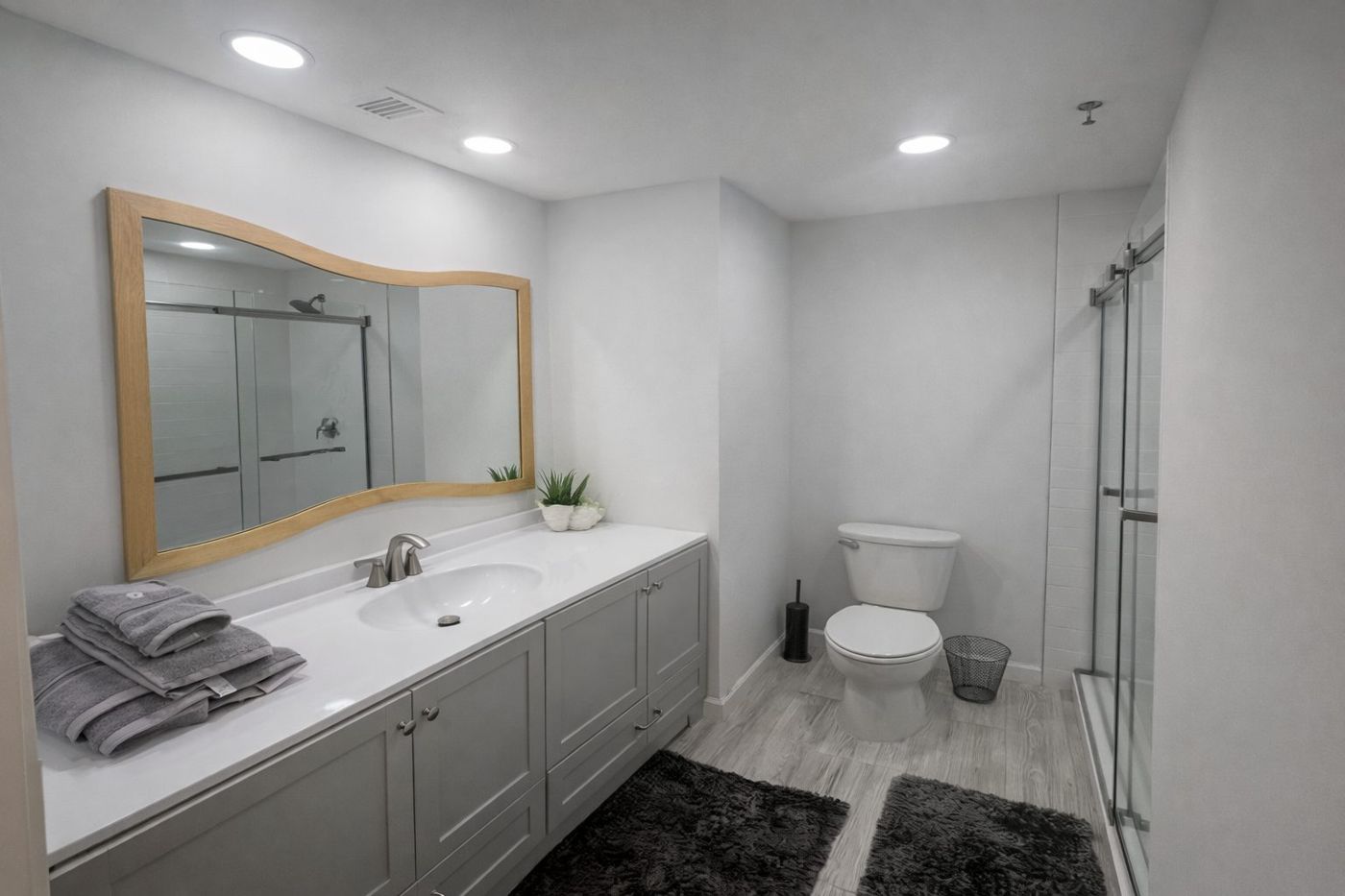 Renovated bathroom with long vanity and glass shower