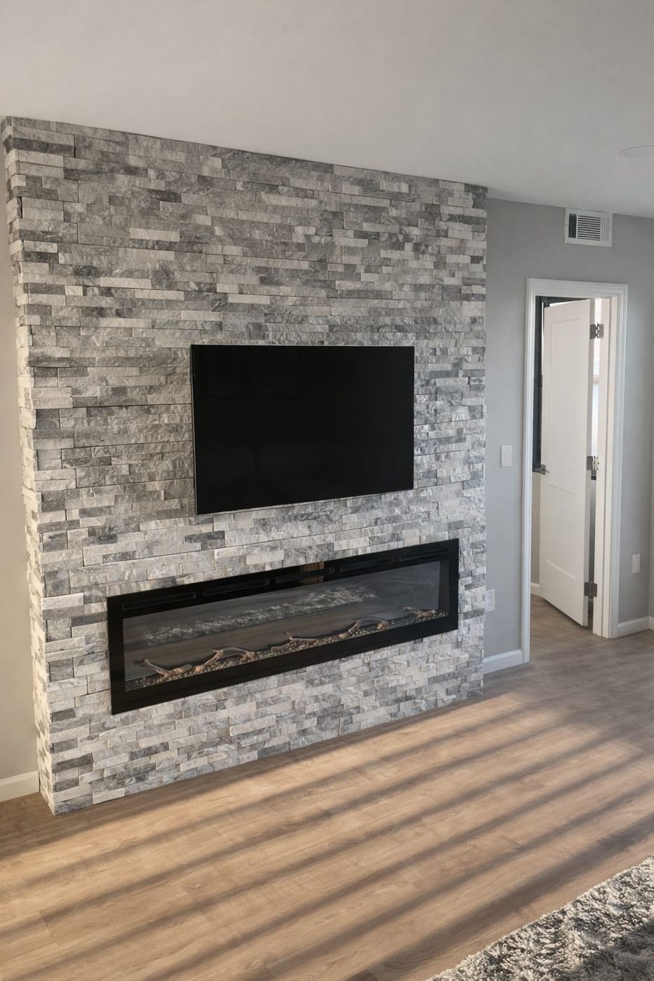 Stacked stone fireplace wall with mounted TV