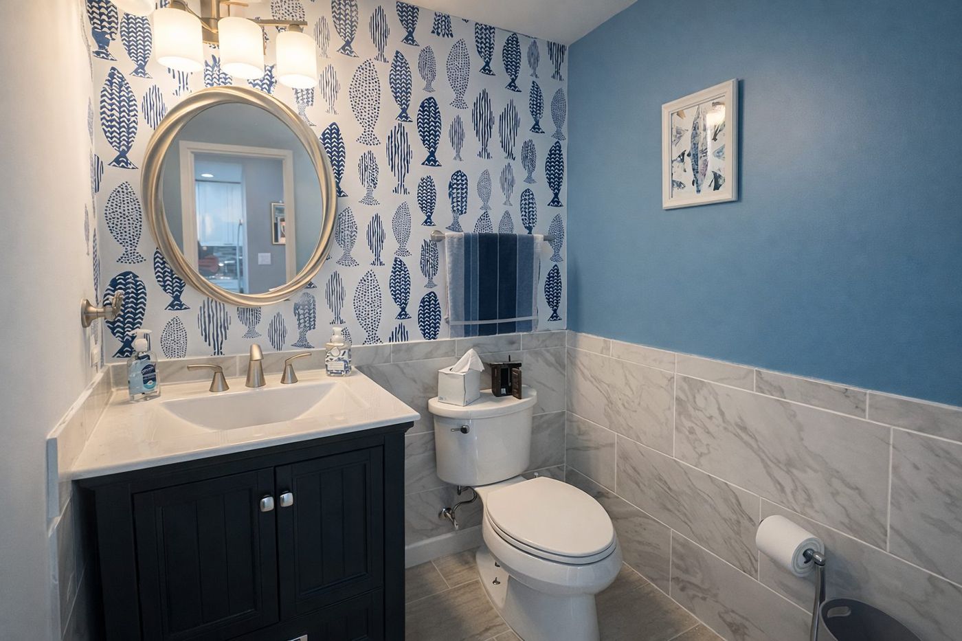 Coastal powder room with fish-print wallpaper