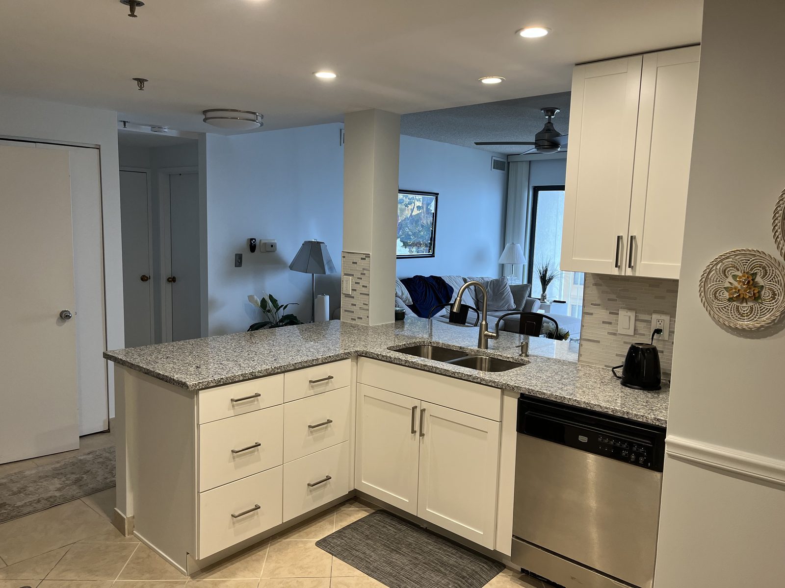 L-shaped kitchen with white shaker cabinets and granite countertops, remodeled by Boardwalk Renovations