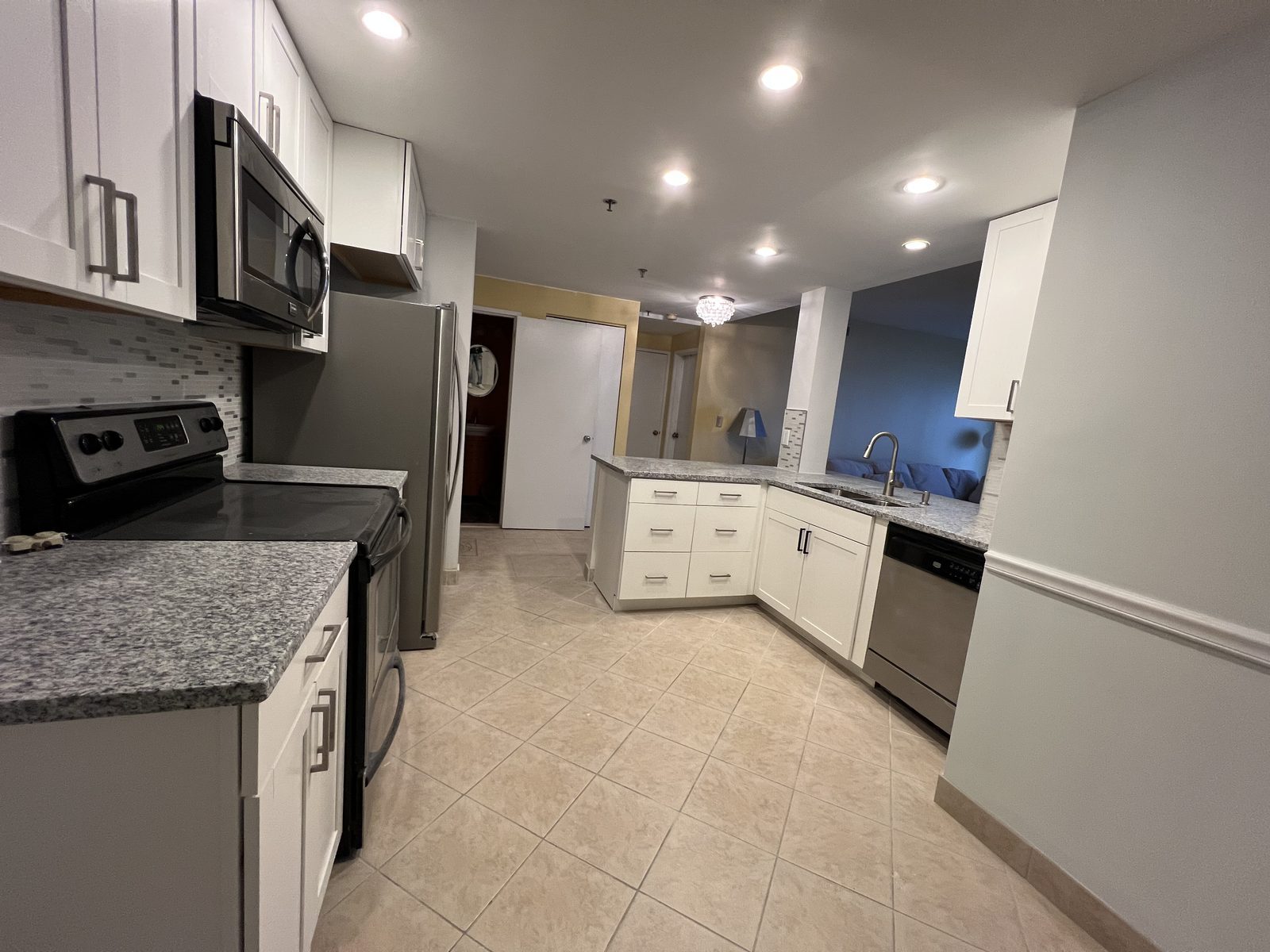 Kitchen with white cabinets, granite countertops and tile floor, remodeled by Boardwalk Renovations