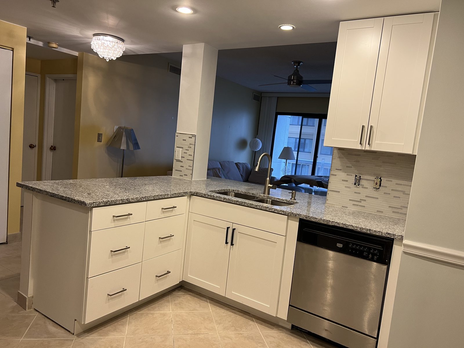L-shaped kitchen with white cabinets, granite countertops and stainless dishwasher, remodeled by Boardwalk Renovations